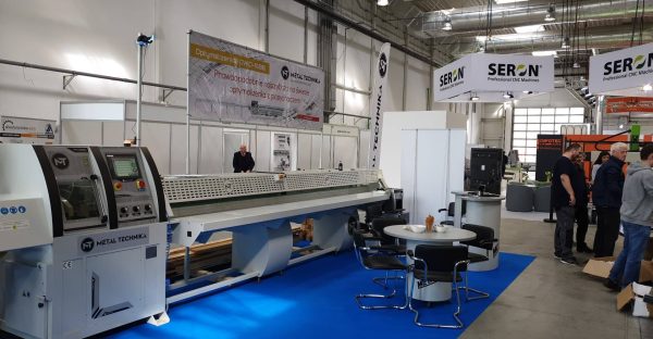 Stoisko na targach przemysłowych prezentujące maszyny CNC Metal Technika i Seron, z operatorami i odwiedzającymi w hali wysta