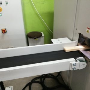 Przemysłowa instalacja elektryczna z białymi listwa oraz czarnymi przewodami, czerwono-żółtymi przyciskami awaryjnymi na ścia