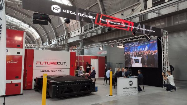 Stoisko firmy Metal Technika na targach przemysłowych. Ekspozycja laserowej maszyny do cięcia, biały kontener, czerwone eleme